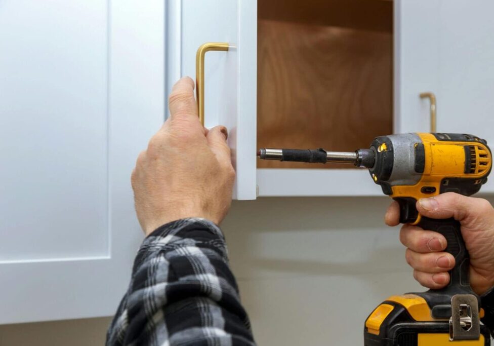 kitchen cabinet installer attaching handles to cabinets